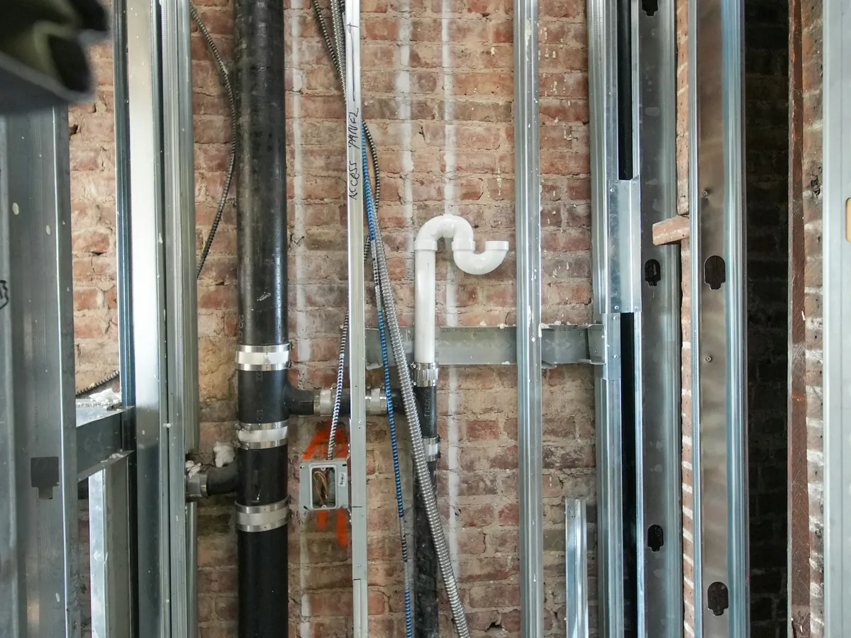 Plumbing lines installed within open framing during a renovation
